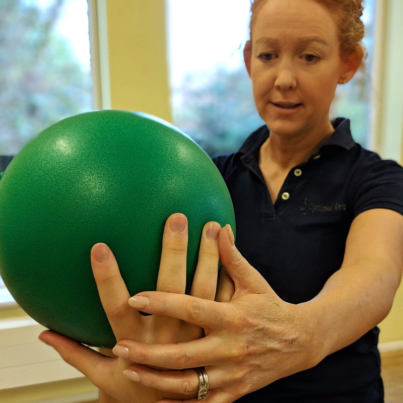 Claire Evans with patient holding small green ball