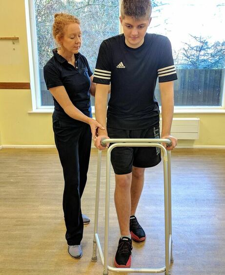 Claire Evans with patient using walking frame